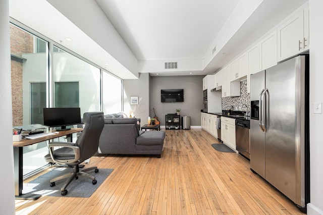 office space featuring light wood-style flooring, visible vents, and baseboards