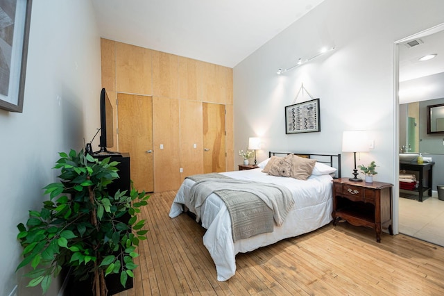 bedroom featuring light wood-type flooring, visible vents, and a closet