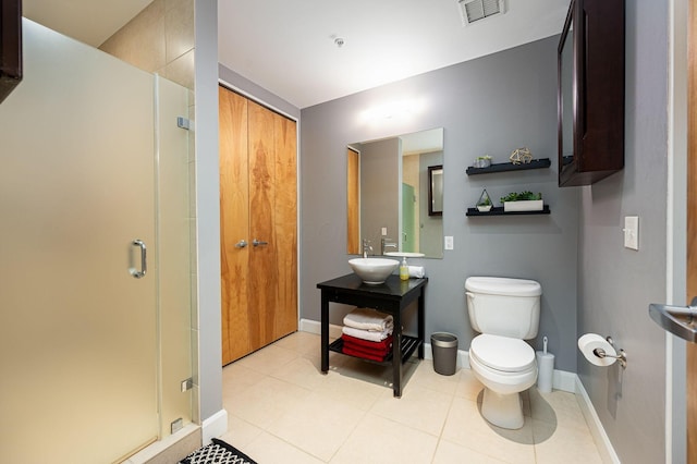 bathroom with toilet, a stall shower, a sink, and visible vents