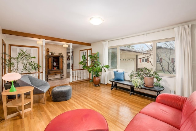 living area with beamed ceiling and wood finished floors