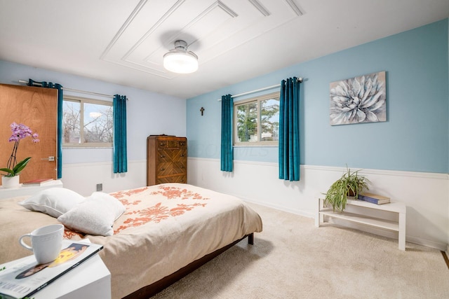 carpeted bedroom featuring attic access and baseboards