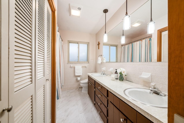 bathroom with a closet, marble finish floor, and a sink