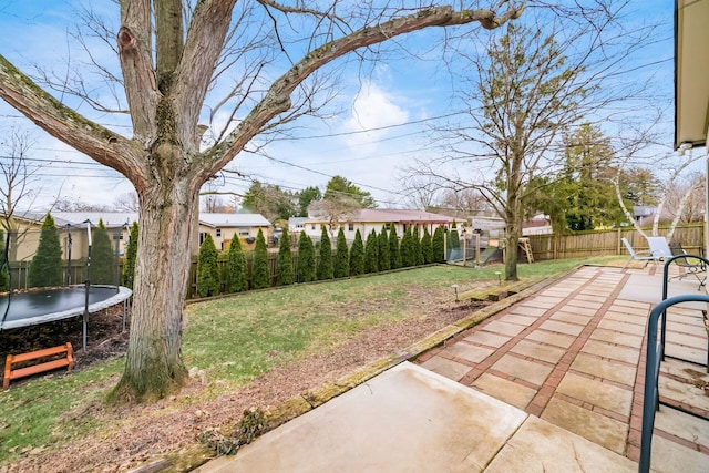 view of yard featuring a fenced backyard, a patio, and a trampoline