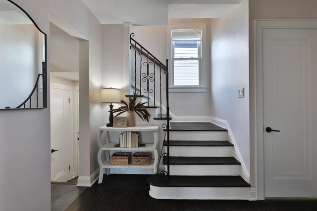 staircase with baseboards and wood finished floors