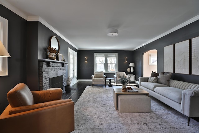 living area with crown molding, arched walkways, a fireplace, and wood finished floors