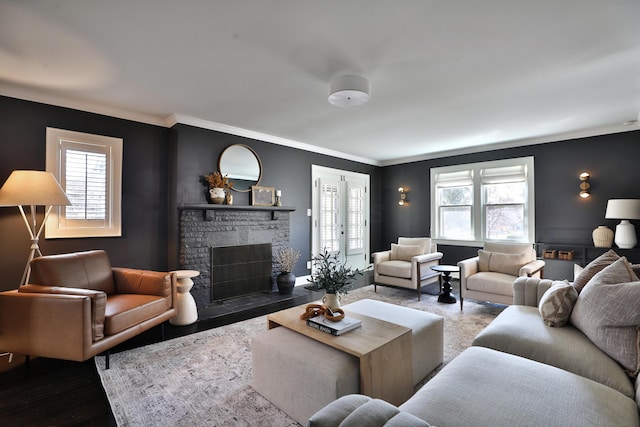 living room featuring crown molding, a fireplace, and wood finished floors