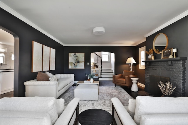 living area featuring dark wood-type flooring, arched walkways, crown molding, and stairs