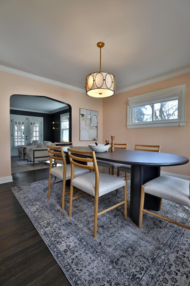 dining area with ornamental molding and arched walkways