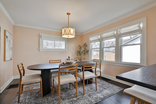 dining area with visible vents, dark wood-type flooring, and ornamental molding