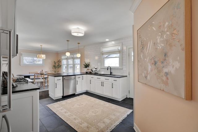 kitchen with dishwasher, dark countertops, a peninsula, white cabinetry, and a sink