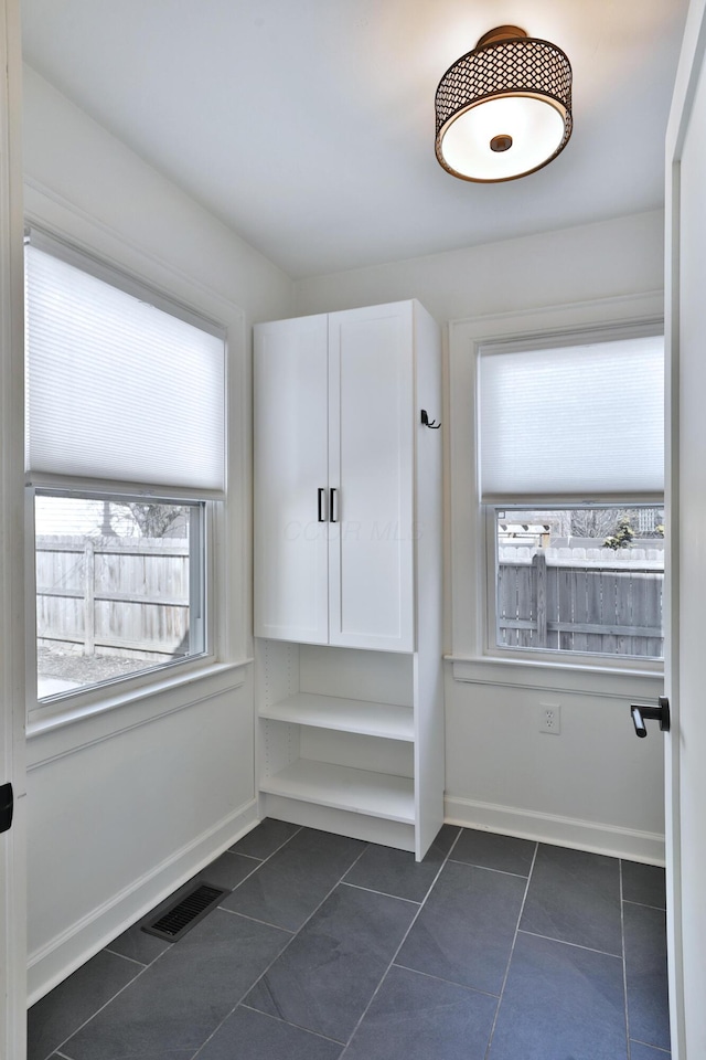 mudroom featuring dark tile patterned floors, visible vents, and baseboards