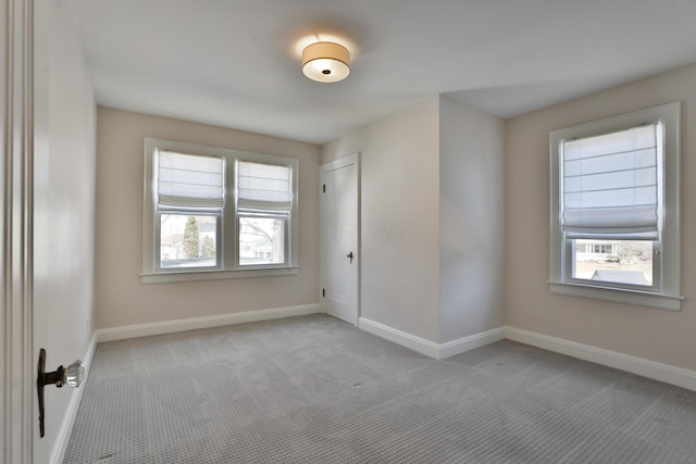 spare room with baseboards and carpet flooring