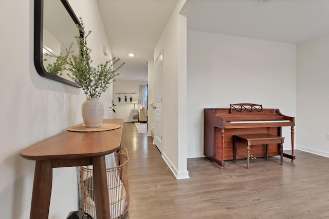 corridor featuring baseboards and wood finished floors