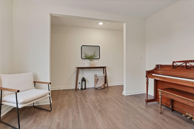 living area featuring baseboards, wood finished floors, and recessed lighting