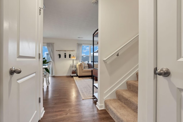 entrance foyer with dark wood-style floors, stairs, and baseboards