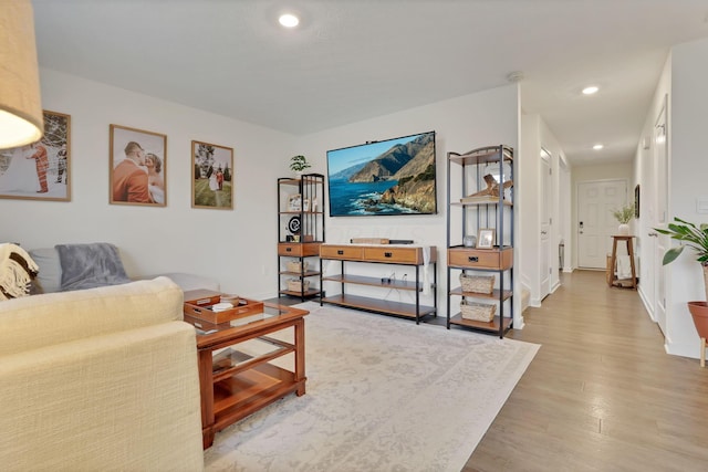 living area with baseboards, wood finished floors, and recessed lighting