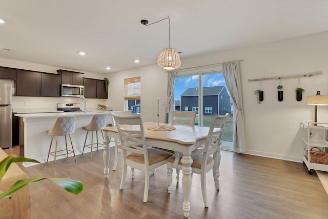 dining room with recessed lighting, baseboards, and wood finished floors