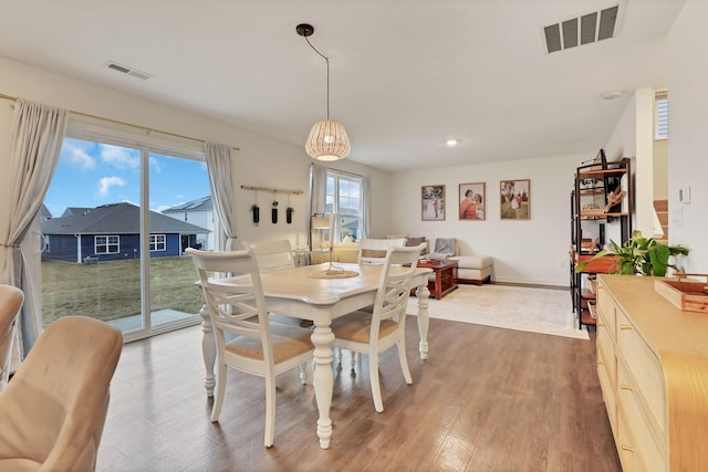 dining room featuring visible vents, baseboards, and wood finished floors