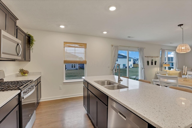 kitchen featuring stainless steel appliances, recessed lighting, a sink, and wood finished floors