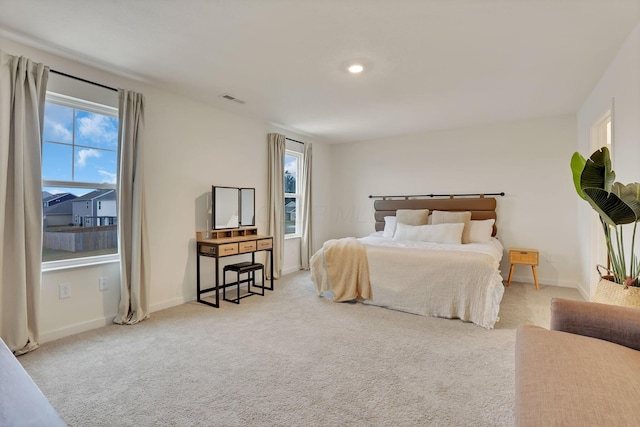 bedroom with multiple windows, carpet flooring, visible vents, and baseboards