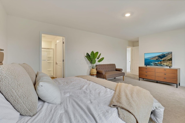 bedroom featuring light carpet and ensuite bath