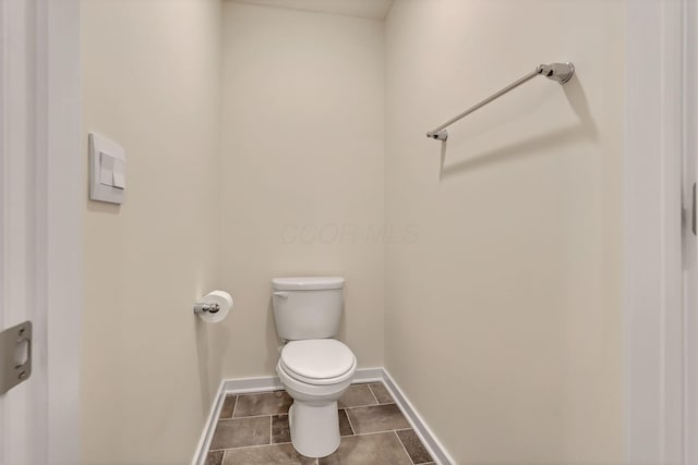 bathroom with tile patterned flooring, toilet, and baseboards