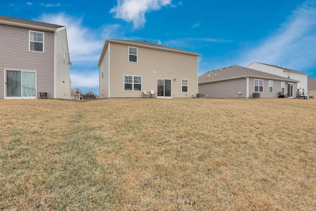 back of property with central AC unit and a lawn