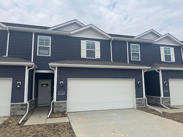 6320 Marinelli Dr S, Columbus, OH 43228 - view of property with stone siding, concrete driveway, roof with shingles, and an attached garage