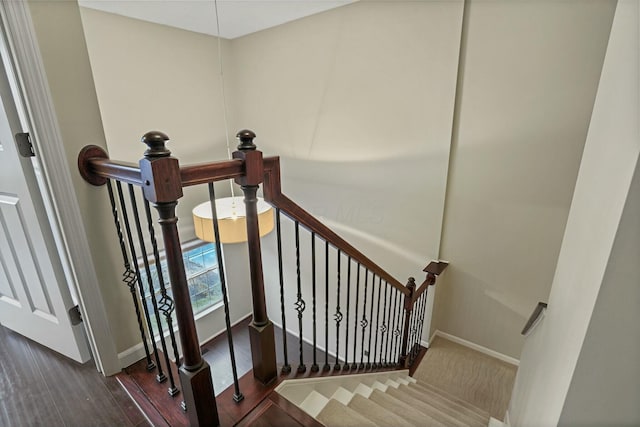 stairway with baseboards and wood finished floors