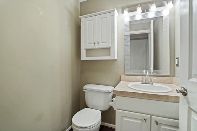 bathroom with baseboards, toilet, and vanity