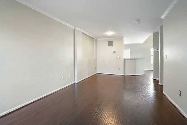 empty room featuring visible vents, baseboards, dark wood finished floors, and ornamental molding