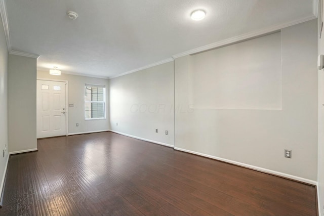 unfurnished room featuring dark wood finished floors, baseboards, and ornamental molding