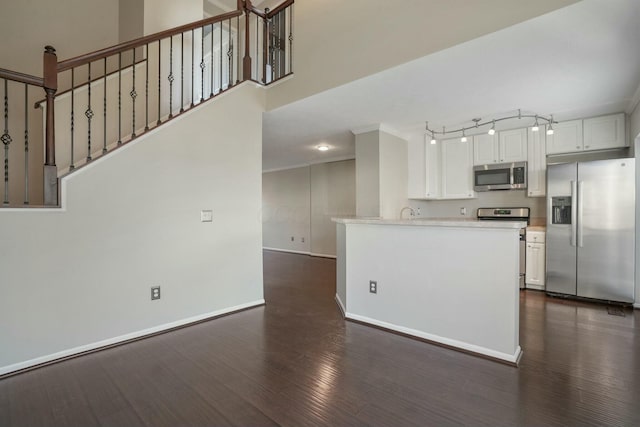 kitchen featuring dark wood-type flooring, baseboards, light countertops, appliances with stainless steel finishes, and white cabinetry