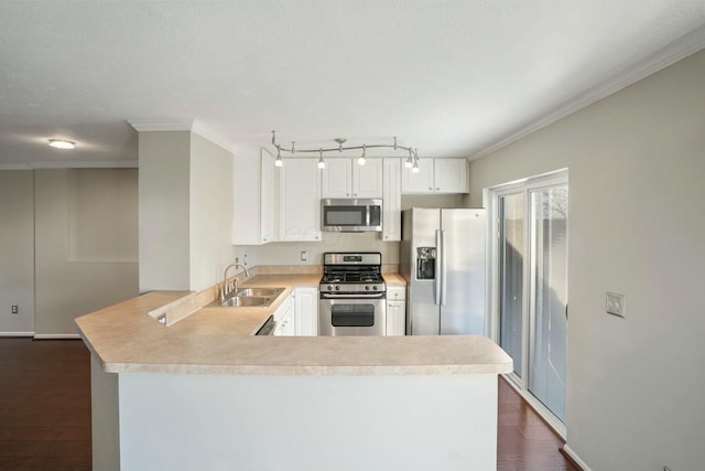 kitchen with a sink, light countertops, a peninsula, stainless steel appliances, and dark wood-style flooring