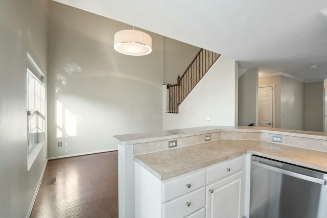 kitchen featuring dark wood-type flooring, baseboards, light countertops, white cabinetry, and stainless steel dishwasher