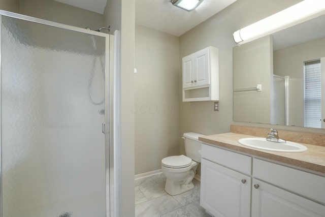 full bathroom with vanity, a shower stall, toilet, and baseboards