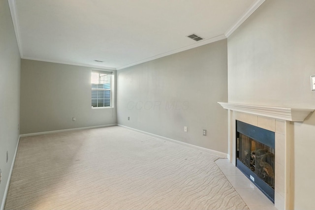 unfurnished living room featuring visible vents, a tile fireplace, crown molding, and baseboards