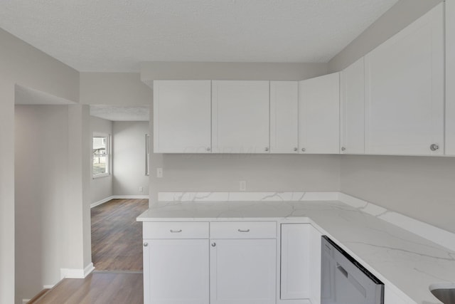 kitchen with light wood finished floors, light stone counters, white cabinets, and a textured ceiling