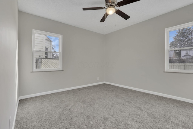 unfurnished room with a textured ceiling, carpet flooring, a ceiling fan, and baseboards