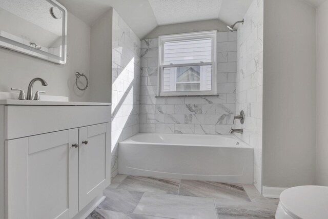 bathroom with toilet, vaulted ceiling, a textured ceiling, shower / tub combination, and vanity