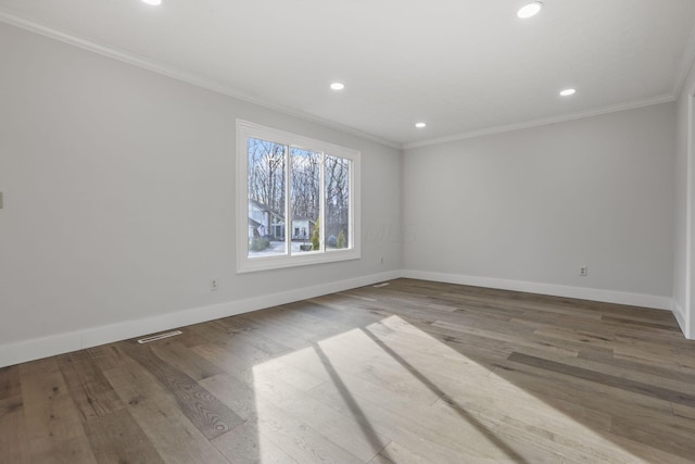 spare room featuring ornamental molding and wood finished floors