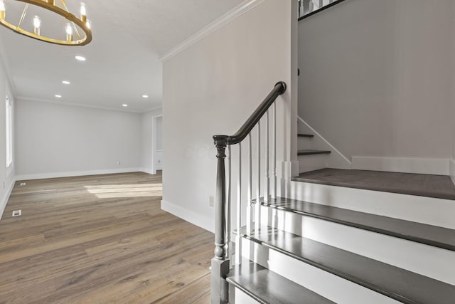 stairway featuring baseboards, ornamental molding, wood finished floors, an inviting chandelier, and recessed lighting