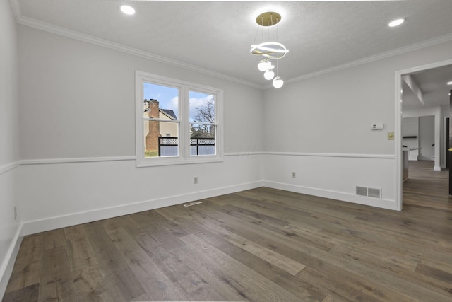 unfurnished room featuring visible vents, crown molding, baseboards, and wood finished floors