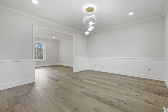 unfurnished room featuring baseboards, wood finished floors, and crown molding