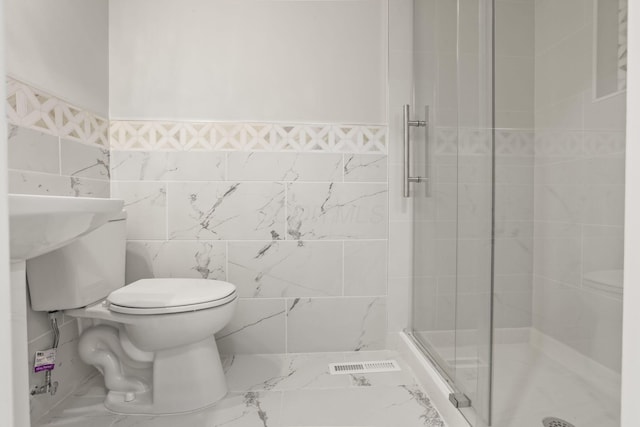 full bath featuring toilet, visible vents, tile walls, marble finish floor, and a stall shower