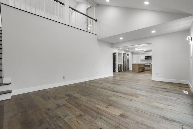 unfurnished living room with recessed lighting, wood finished floors, and baseboards