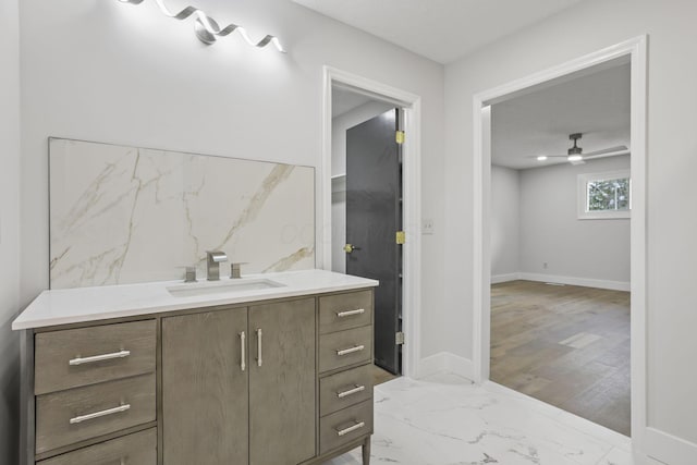 bathroom with baseboards, marble finish floor, vanity, and a ceiling fan