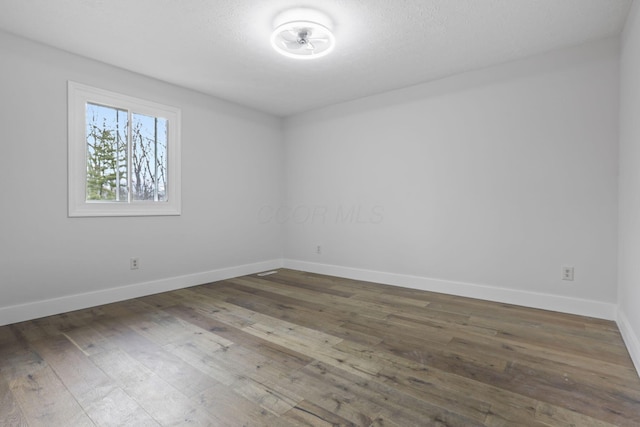 unfurnished room featuring baseboards and hardwood / wood-style floors