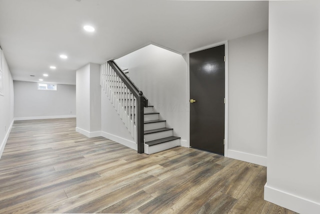 foyer featuring stairs, baseboards, wood finished floors, and recessed lighting