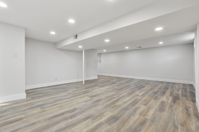 finished below grade area with recessed lighting, visible vents, baseboards, and wood finished floors